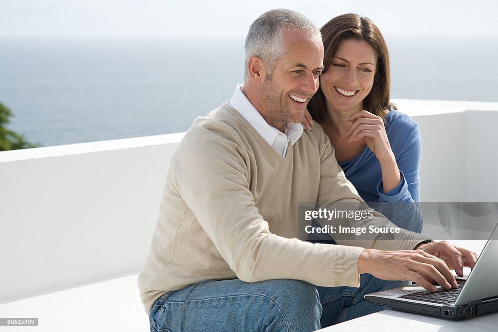 Un couple à l'aide d'un ordinateur portable