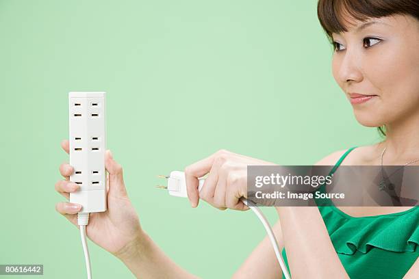 woman with extension cord - power strip stock pictures, royalty-free photos & images