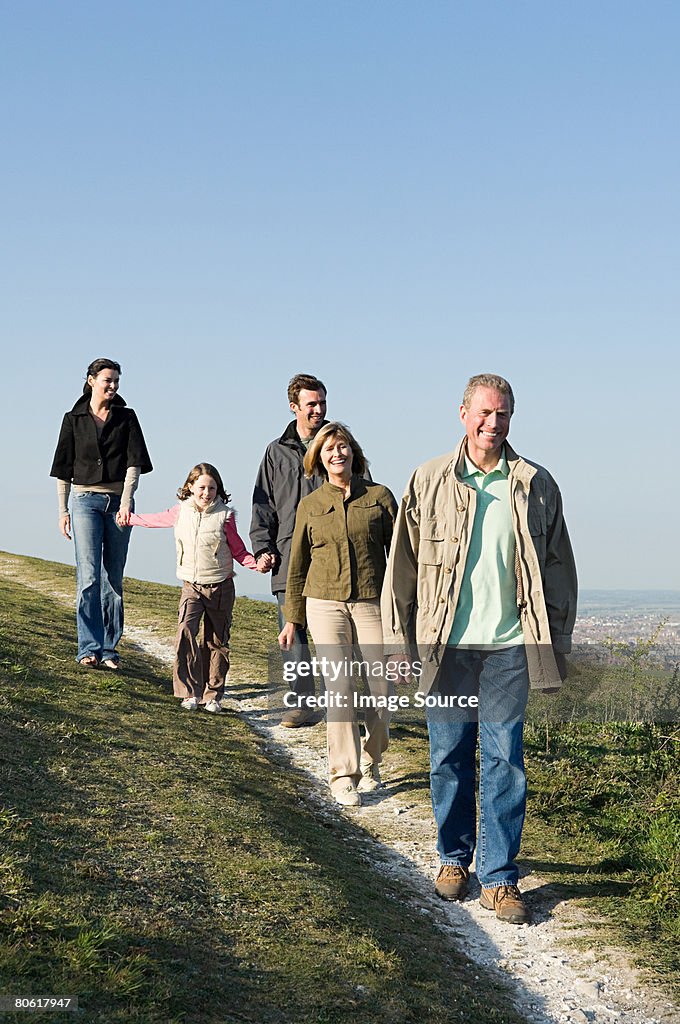 Family walking on grassy hill