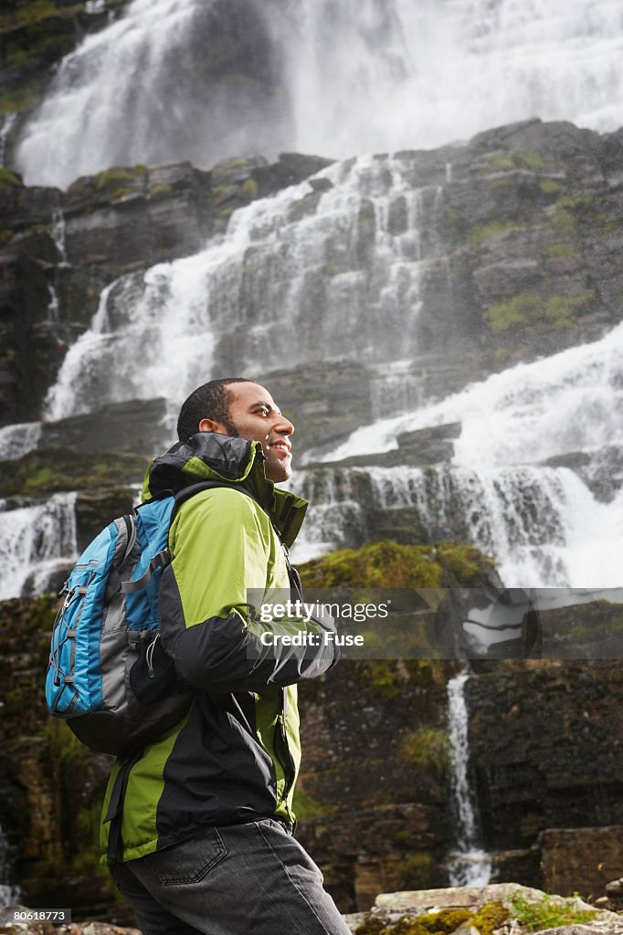 Man Standing near Waterfall