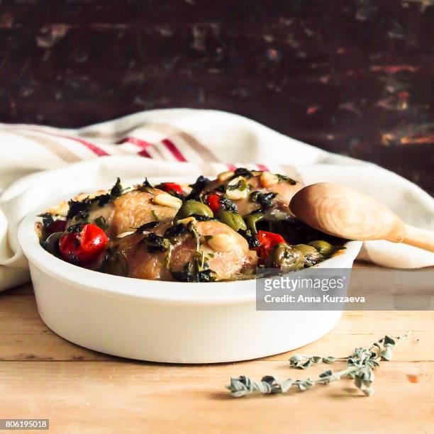 roasted chicken meat with green olives and cherry tomatoes in a bowl, selective focus - geköchelt stock-fotos und bilder