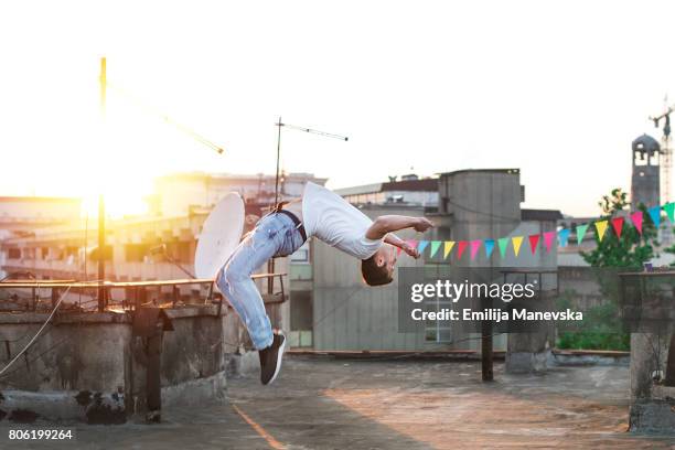 young man practicing parkour on a rooftop - stunt person 個照片及圖片檔