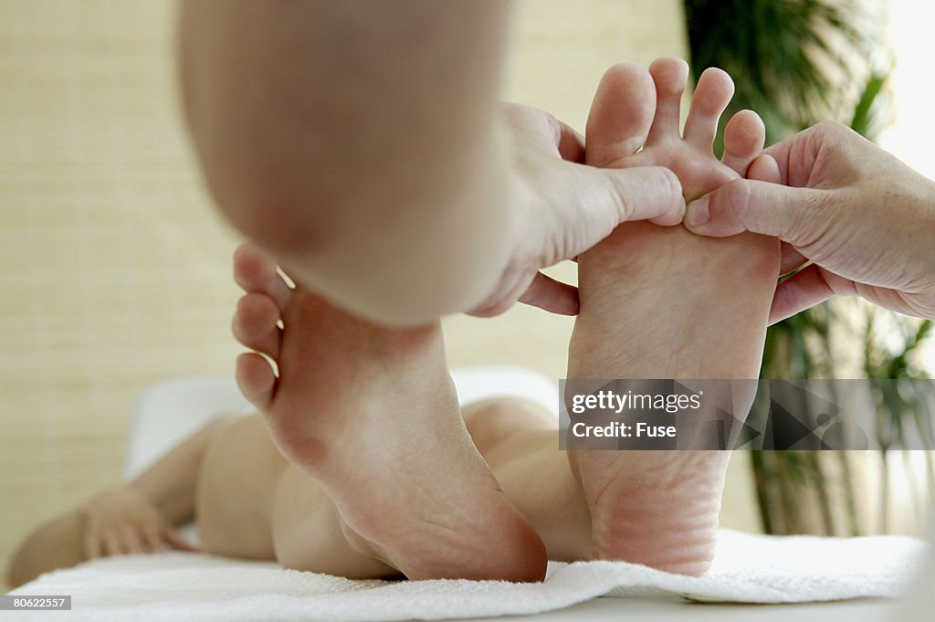 Masseuse massaging woman's feet