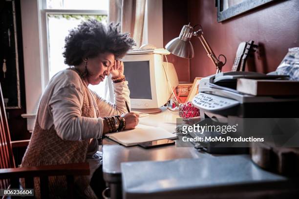 portrait of woman with cool hair in home office - schreibtischlampe stock-fotos und bilder