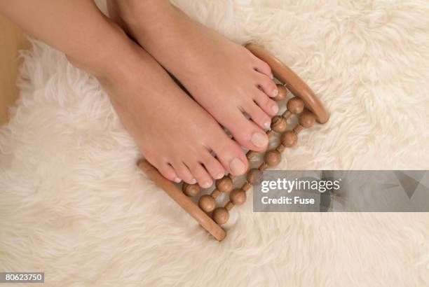 feet of woman on massage roller - hairy woman stockfoto's en -beelden