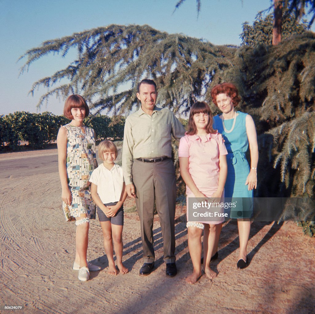 Couple with three children standing in yard