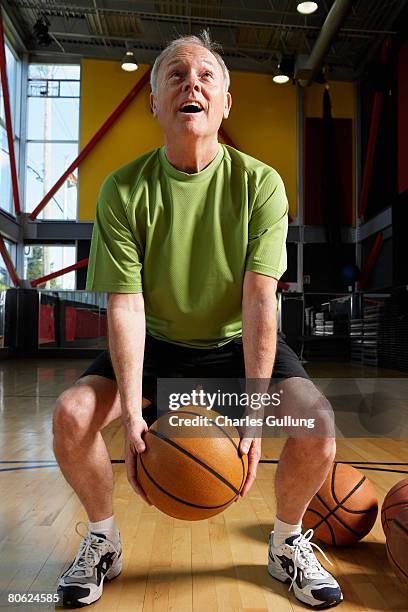 senior man practicing basketball at gym - repetição evento esportivo imagens e fotografias de stock