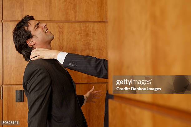 businessman's hand strangling another businessman's neck - suffocated stock-fotos und bilder