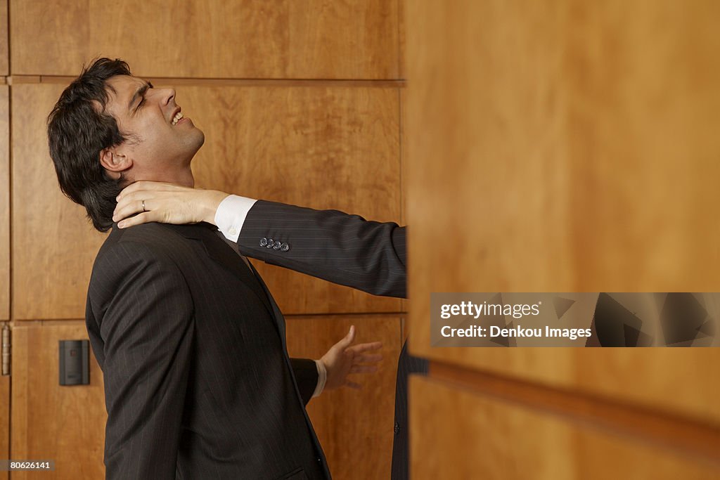 Businessman's hand strangling another businessman's neck