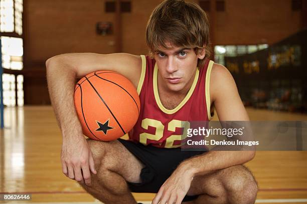 portrait of a young man holding a basketball - cheveux court homme photos et images de collection