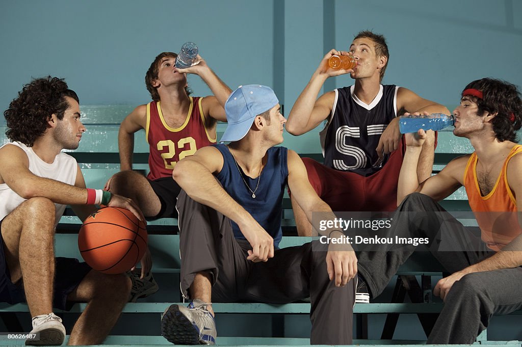 Five young men sitting on a bench