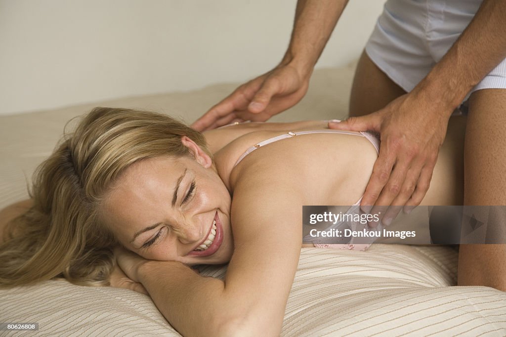 Young woman receiving back massage from a man