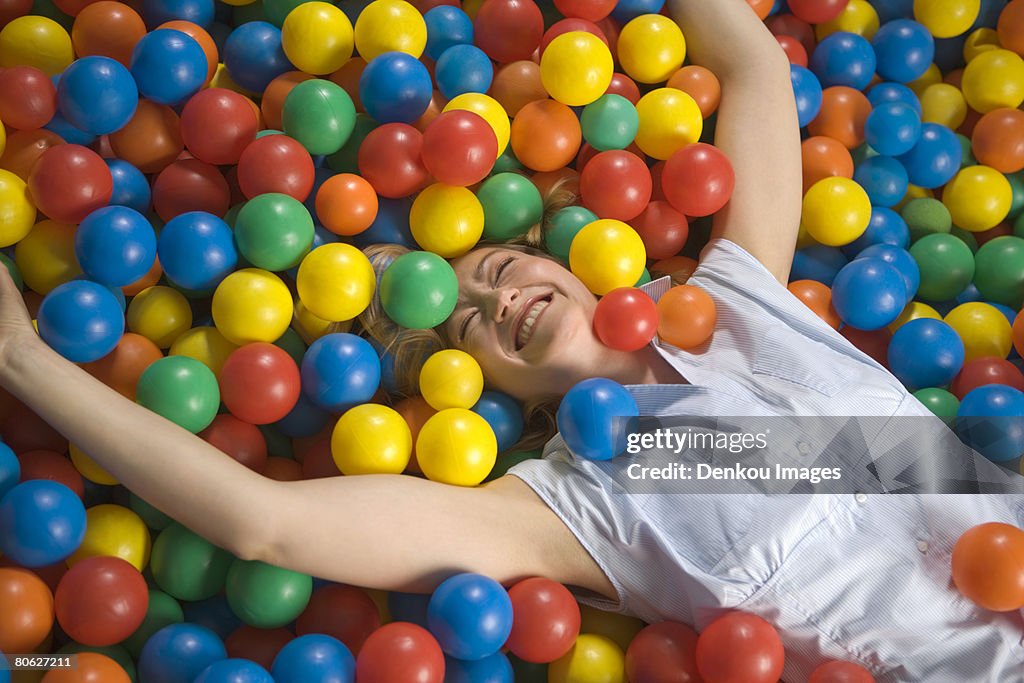 High angle view of a mid adult woman lying a in ball pool