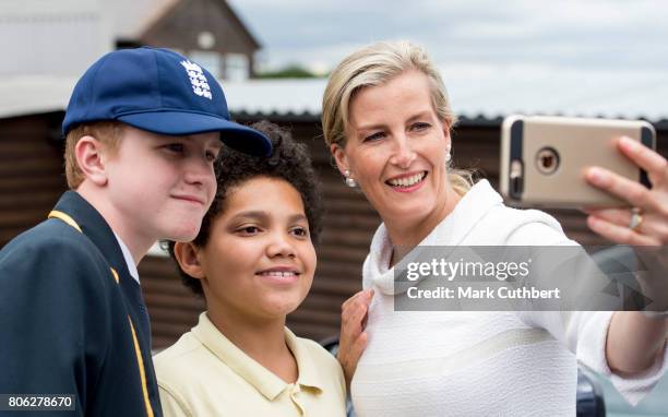 Sophie, Countess of Wessex, patron of London Children's Flower Society takes a selfie photo with two pupils on her iPhone during a visit to Baston...