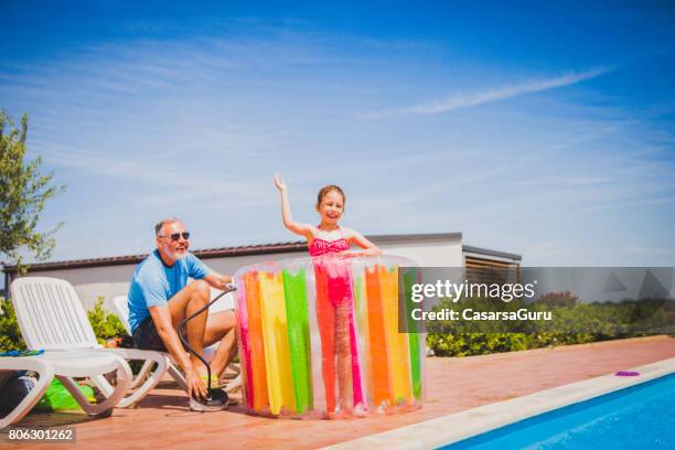 day dreaming at the swimming pool - father pumping water heel toy for his daughter - water mill kids stock pictures, royalty-free photos & images