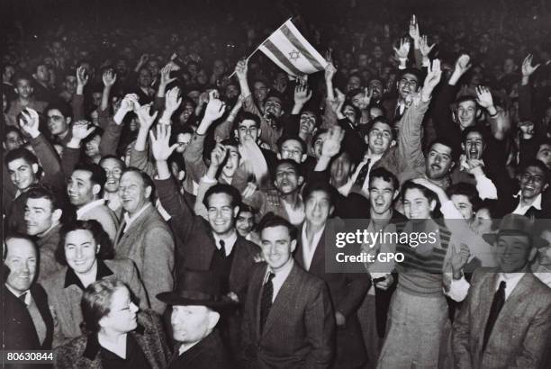 Jubilant residents celebrate with what would become the Israeli flag after the United Nations decision to approve the partition of Palestine November...