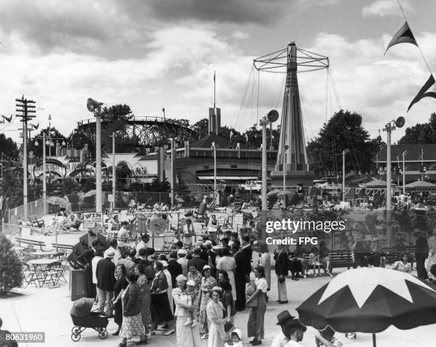 Visitors at the Palisades Amusement Park, New Jersey, which boasts a sandy 'beach' enclosure and fairground rides, circa 1947.