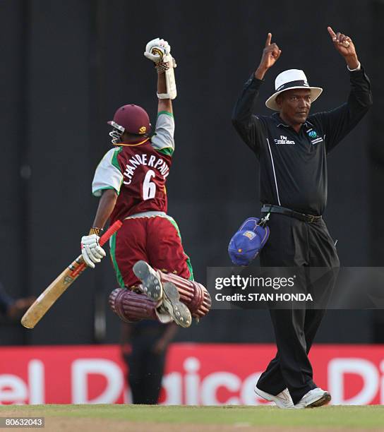 As umpire Clay Duncan signals, West Indies batsman Shivnarine Chanderpaul jumps to celebrate his six that won the match on the last ball against Sri...