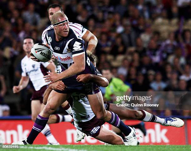 Michael Crocker of the Storm is tackled during the round five NRL match between the Melbourne Storm and the Manly Warringah Sea Eagles at Olympic...