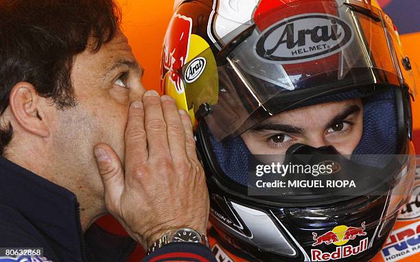 Moto GP driver spanish Dani Pedrosa listens his manager Alberto Puig in the box before the first free practice session of the Grand Prix of Portugal...