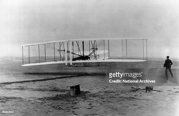 The original Wright Brothers 1903 Aeroplane during it's first flight December 17, 1903 in Kitty Hawk, North Carolina. With Orville Wright at the...