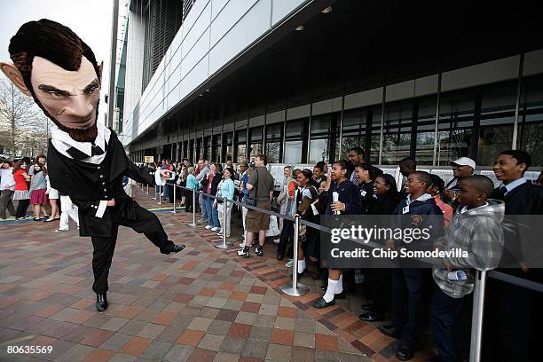 The Abraham Lincoln mascot from the Nationals Major League Baseball team entertains school children as they wait in line to enter the grand opening...