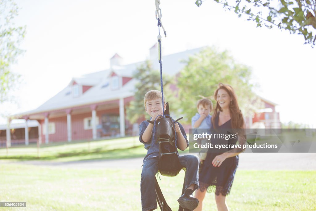 媽媽和男孩在農村科羅拉多州農場上蕩秋千