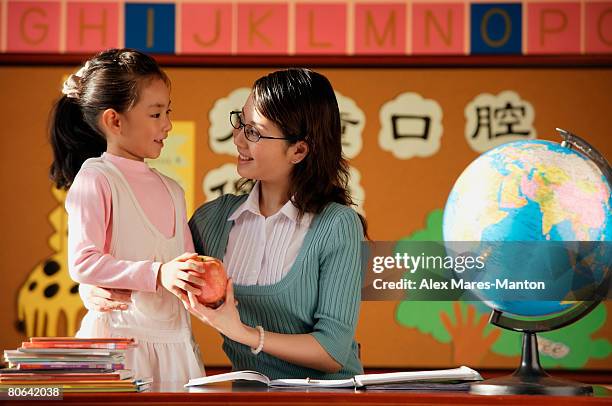 schoolgirl giving teacher an apple - queridinho do professor - fotografias e filmes do acervo