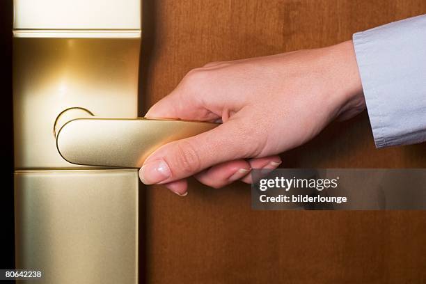 detail of female hand opening door to hotel room - handle stock-fotos und bilder