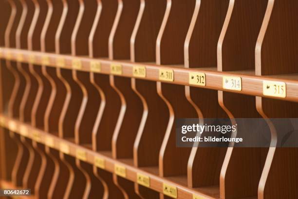still life of empty pigeon holes at hotel reception - pigeon hole stock pictures, royalty-free photos & images