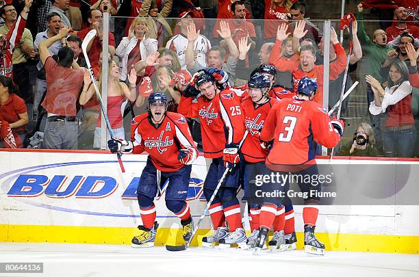 Alex Ovechkin of the Washington Capitals celebrates with teammates after scoring the game winning goal against the Philadelphia Flyers during game...