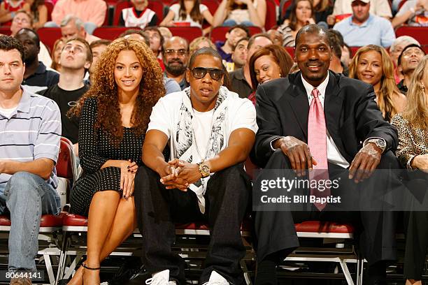 And hip-hop Beyonce Knowles and Jay-Z watch the game with NBA legend and Hall of Fame inductee Hakeem Olajuwon at the Toyota Center April 11, 2008 in...