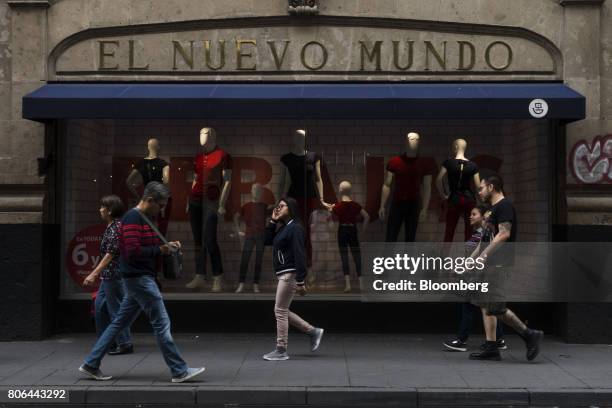 Pedestrians pass in front of an El Nuevo Mondo store on Francisco I. Madero Avenue in Mexico City, Mexico, on Monday, June 26, 2017. The National...