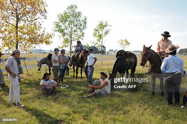 Students of the "rational" wild horse taming course dictated by Uruguayan instructor Marcelo Gonzalez stand by for instructions at the Agricultural...