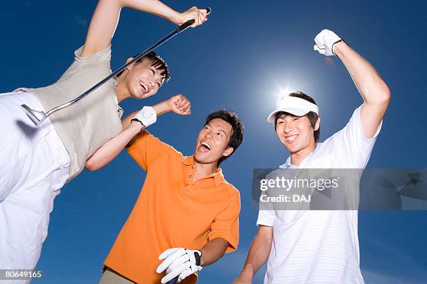 three golfers smiling under the blue sky, punching the air, blue background, lens flare, saipan, usa  - portrait lens flare stock pictures, royalty-free photos & images