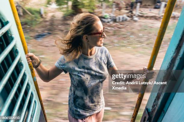 young woman rides train through rural area - leanincollection ストックフォトと画像