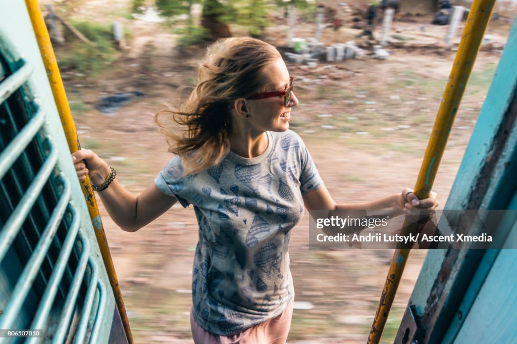 Young woman rides train through rural area