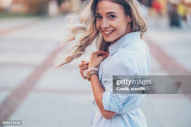 smiling woman walking in the city - wind swept face stock pictures, royalty-free photos & images