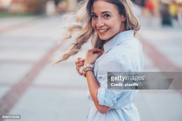 smiling woman walking in the city - joia imagens e fotografias de stock
