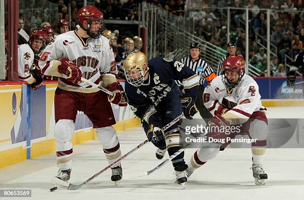 Mark Van Guilder of the Notre Dame Fighting Irish tries to control the puck while under pressure form Nick Petrecki and Tim Kunes of the Boston...