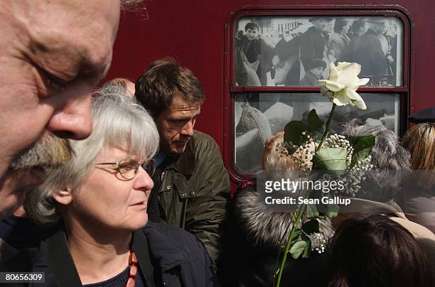 Woman holding a flower is among visitors waiting to see the travelling Holocaust exhibition ?Train of Commemoration? at Ostbahnhof train station on...