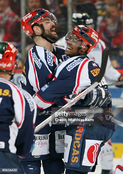 Denis Pederson of Berlin jubilates with team mate Nathan Robinson after scoring the first goal during the DEL Play-Offs Final match between EHC...