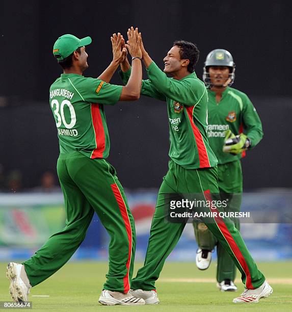 Bangladesh cricketer Shakib al Hasan celebrates with teammate Mahmud Ullah after taking the wicket of Pakistani cricketer Shahid Afridi during the...