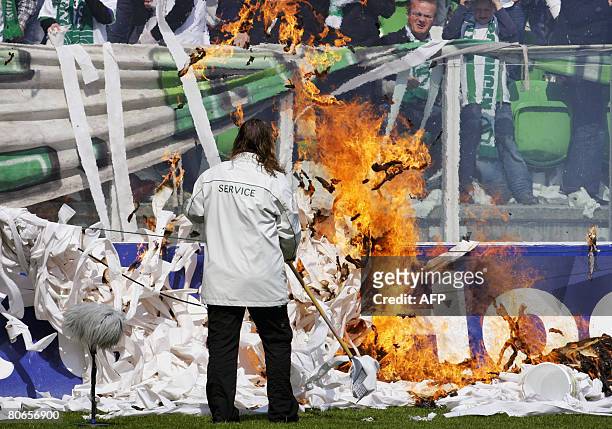 Stadium employee removes burning papers after supporters allegedly set fire in the stadium of FC Groningen prior to the match FC Groningen vs Ajax,...
