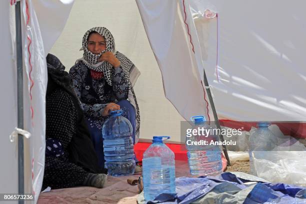 Woman holds a water bottle supplied to the families by Lebanese Red Cross staff at the Qob Elias refugee camp after a big fire broke out on Sunday,...