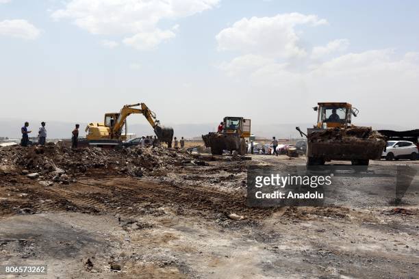 Heavy construction machines collect the remains of fire that broke out on Sunday, at Qob Elias refugee camp in Beqaa, Lebanon on July 3, 2017....