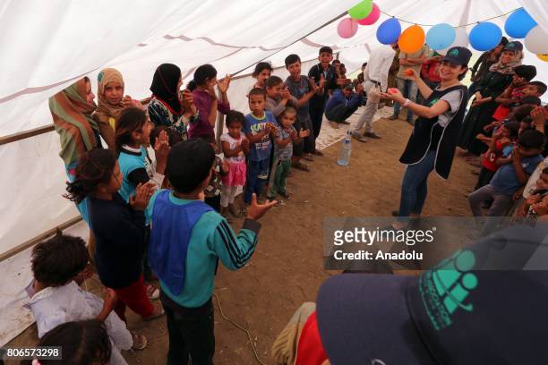 People gesture as they are helped by United Nations teams and Lebanese Red Cross staff within the infrastructure works at the Qob Elias refugee camp...