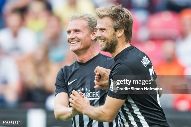 Moritz Fuerste of Schumacher and Friends celebrates his team's first goal with team mate David Coulthard during the Champions for Charity Friendly...