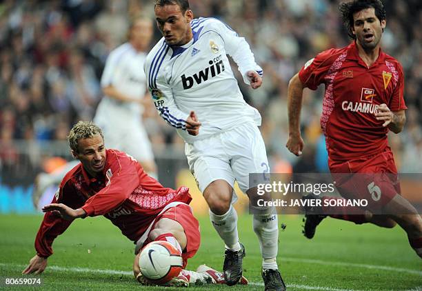 Real Madrid's Wesley Sneijder shoots and scores past Murcia's Jean Fran?ois Pignol and C?sar Arzo during a Spanish league football match at the...