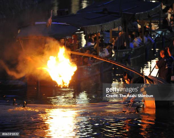 Spectators on boats are enchanted by the traditional fishing method where "usho" anglers make catches using cormorants on the Ujigawa river on July...